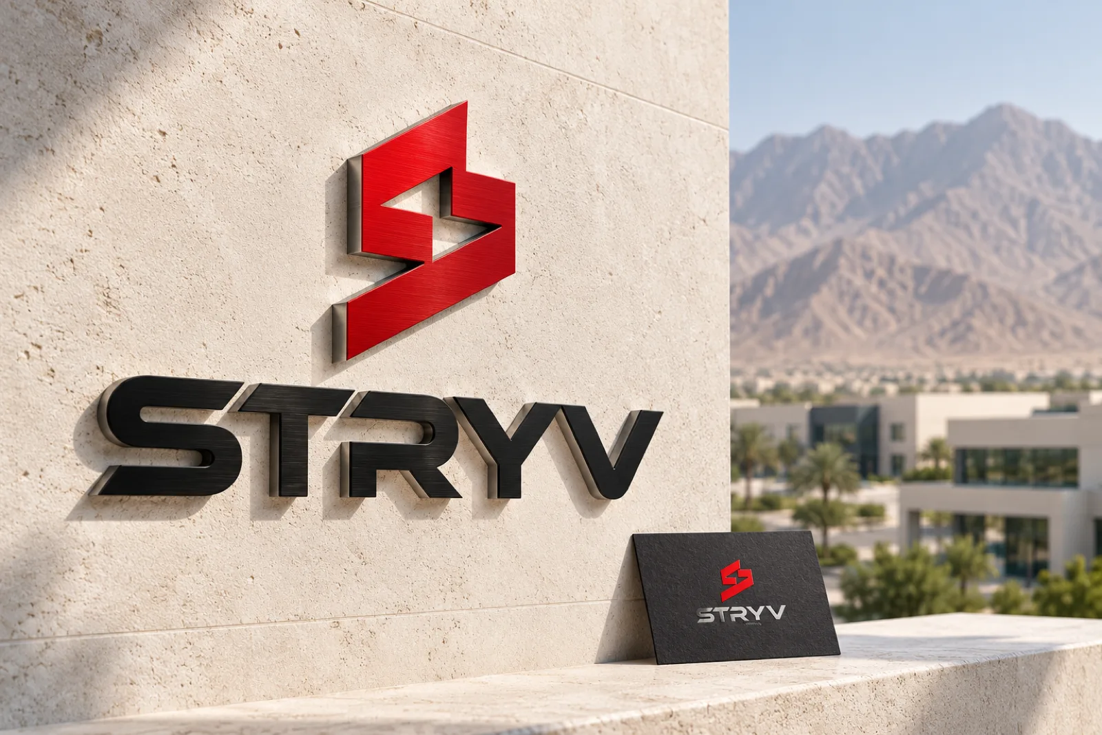 A dimensional logo sign and embossed business card for Stryv in a calm setting, with mountains behind a business park in Ras Al Khaimah softly in the background.