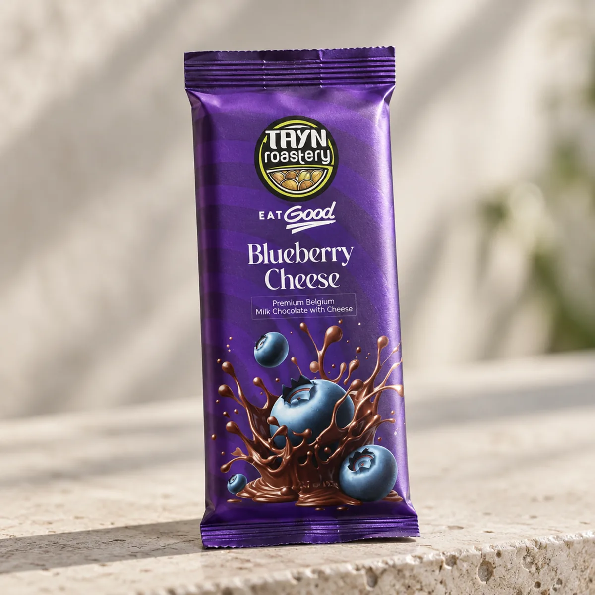 A sealed Tayn Roastery chocolate pack with a crimped top on a pale stone ledge