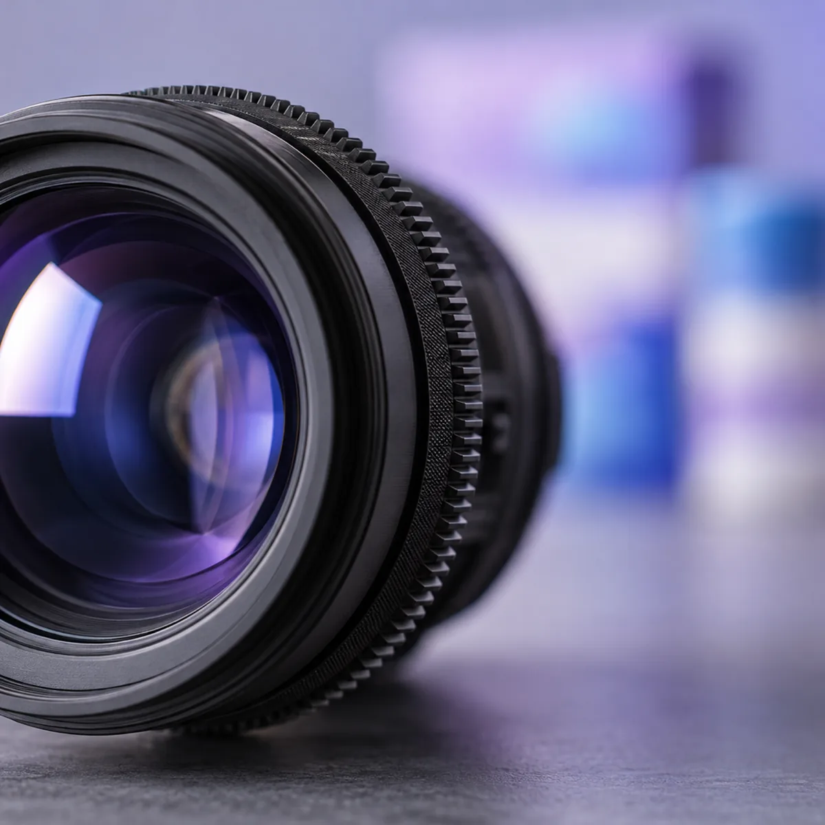 A cinema lens up close with a Velvia set blurred behind it