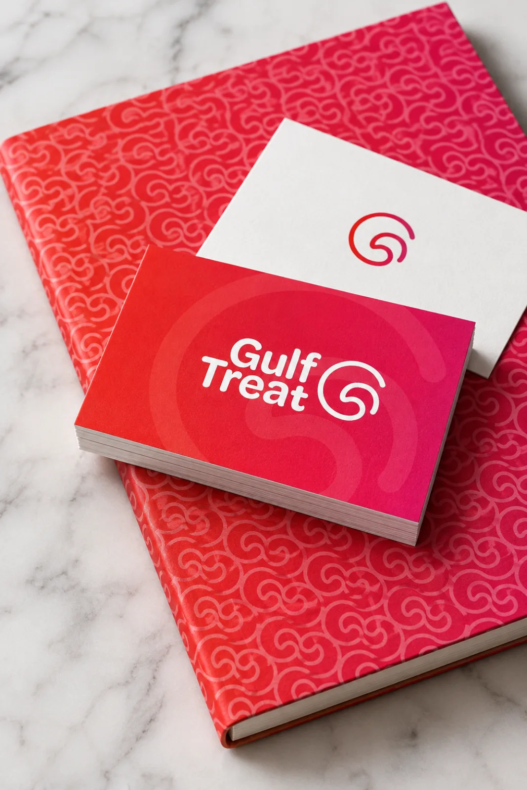 Gulf Treat business cards with the gradient front and a patterned notebook on marble