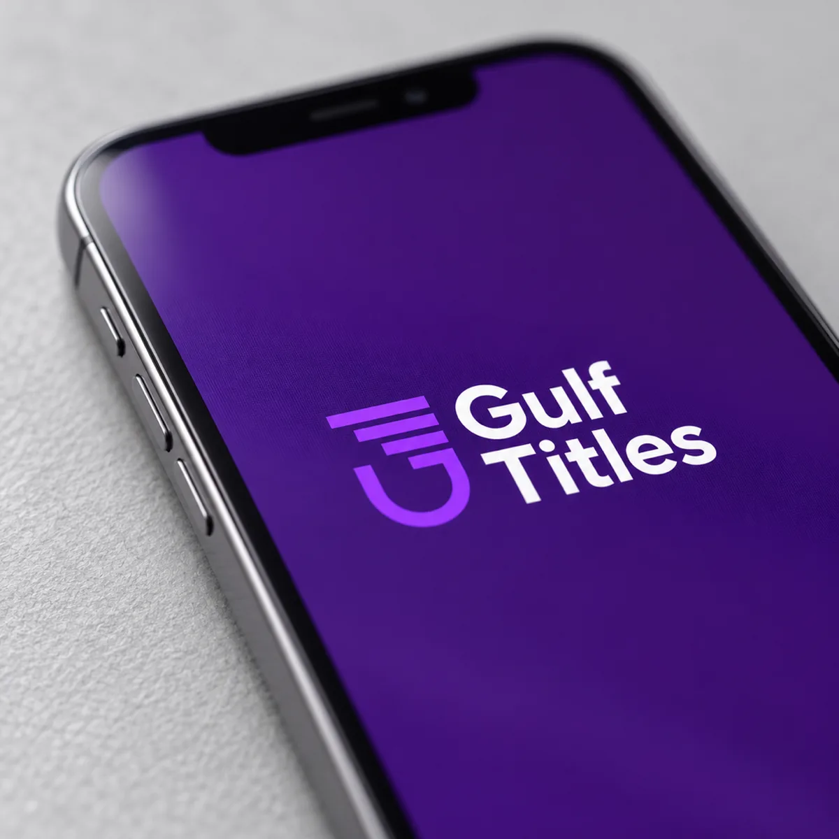 A close-up of a phone at a low angle with the Gulf Titles logo in focus on a purple post.