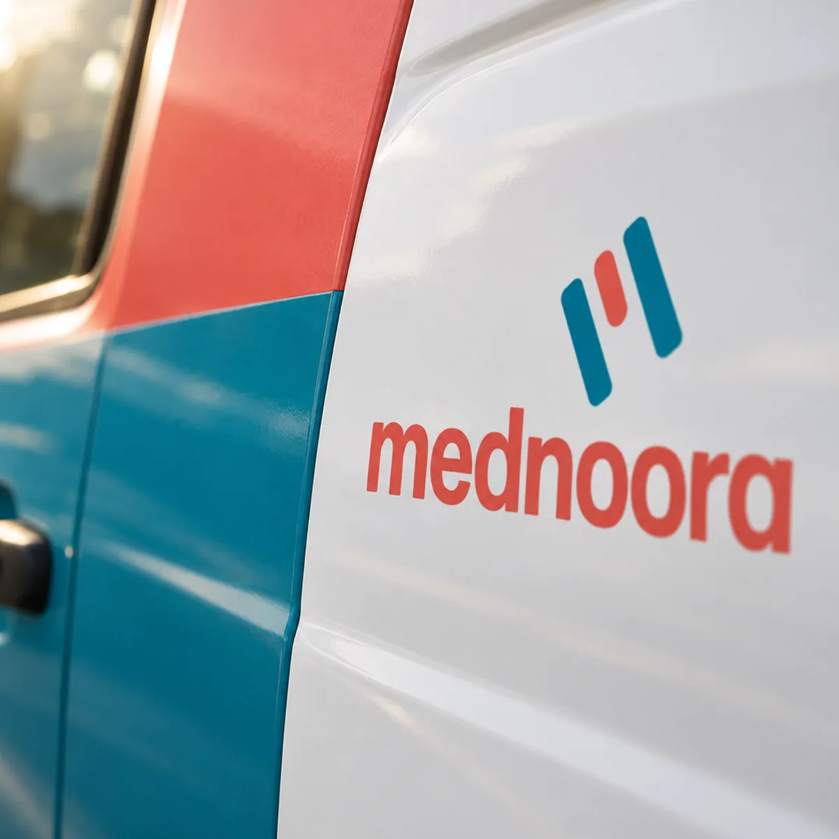 Coral and teal vinyl livery meeting on the side of a white Mednoora van with the logo