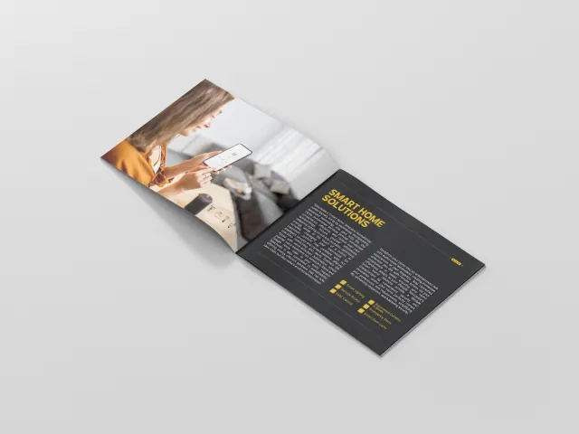 A smart-home solutions brochure: a black spread with yellow headings beside a photograph of a person using a phone.