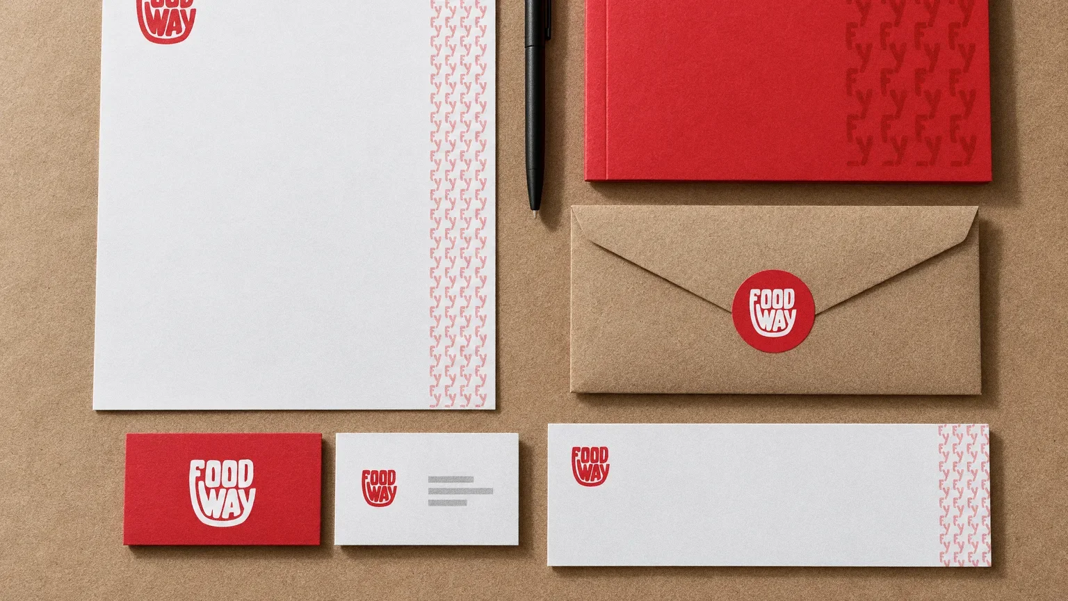 A top-down stationery set on kraft paper: red and white business cards, a letterhead with an F and Y pattern edge, a kraft envelope with a round logo sticker, a red folder and a pen.