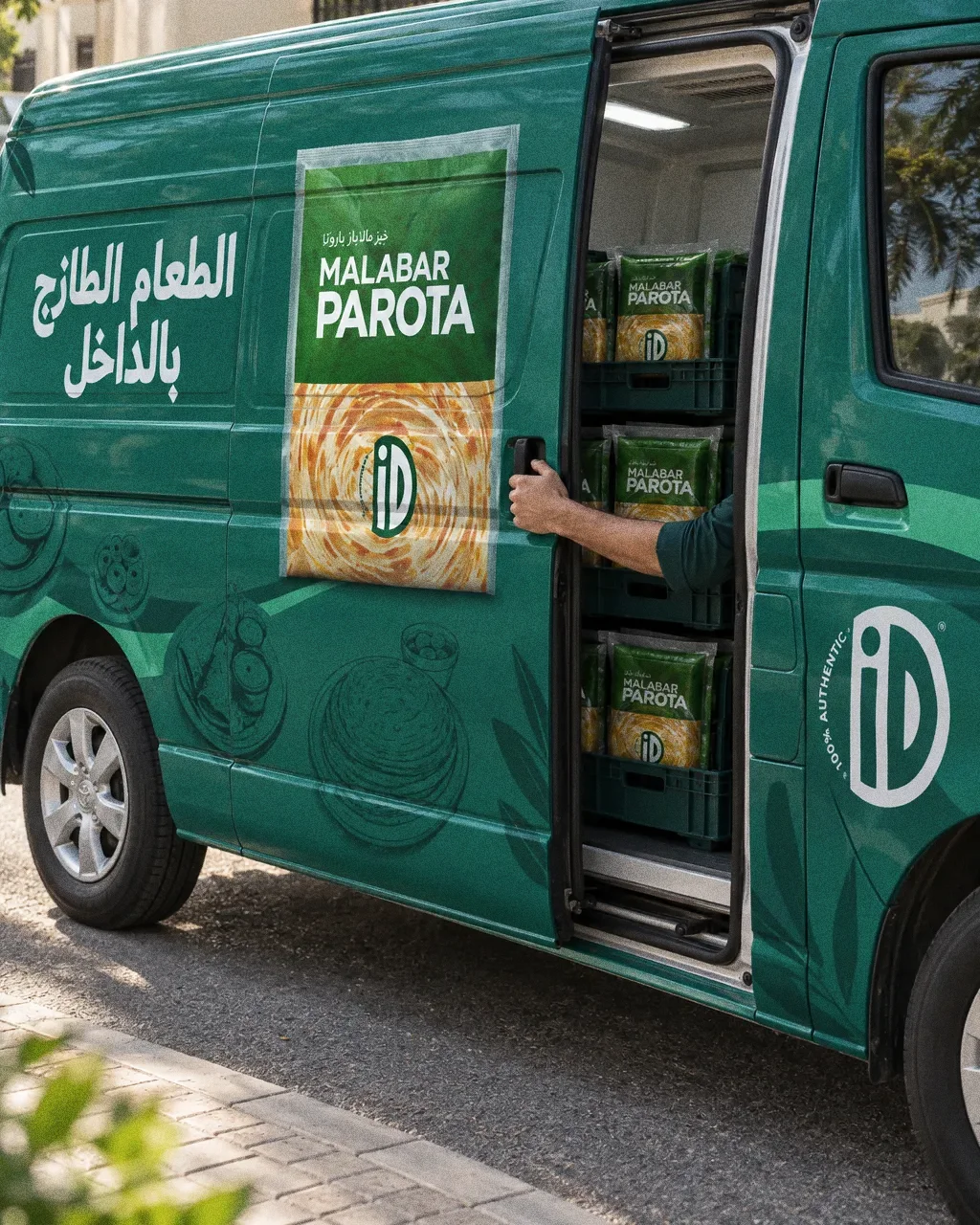 The Arabic side of the iD Fresh Food van with the Malabar Parota pack window, its sliding door opened onto chilled crates.
